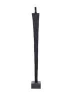 Straight-on view of a tall textured black abstract figure with broad shoulders and a tapering body on a grey block base.