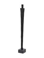 Angled view of the slender black figure sculpture showing the depth of its rectangular head, body and square base.