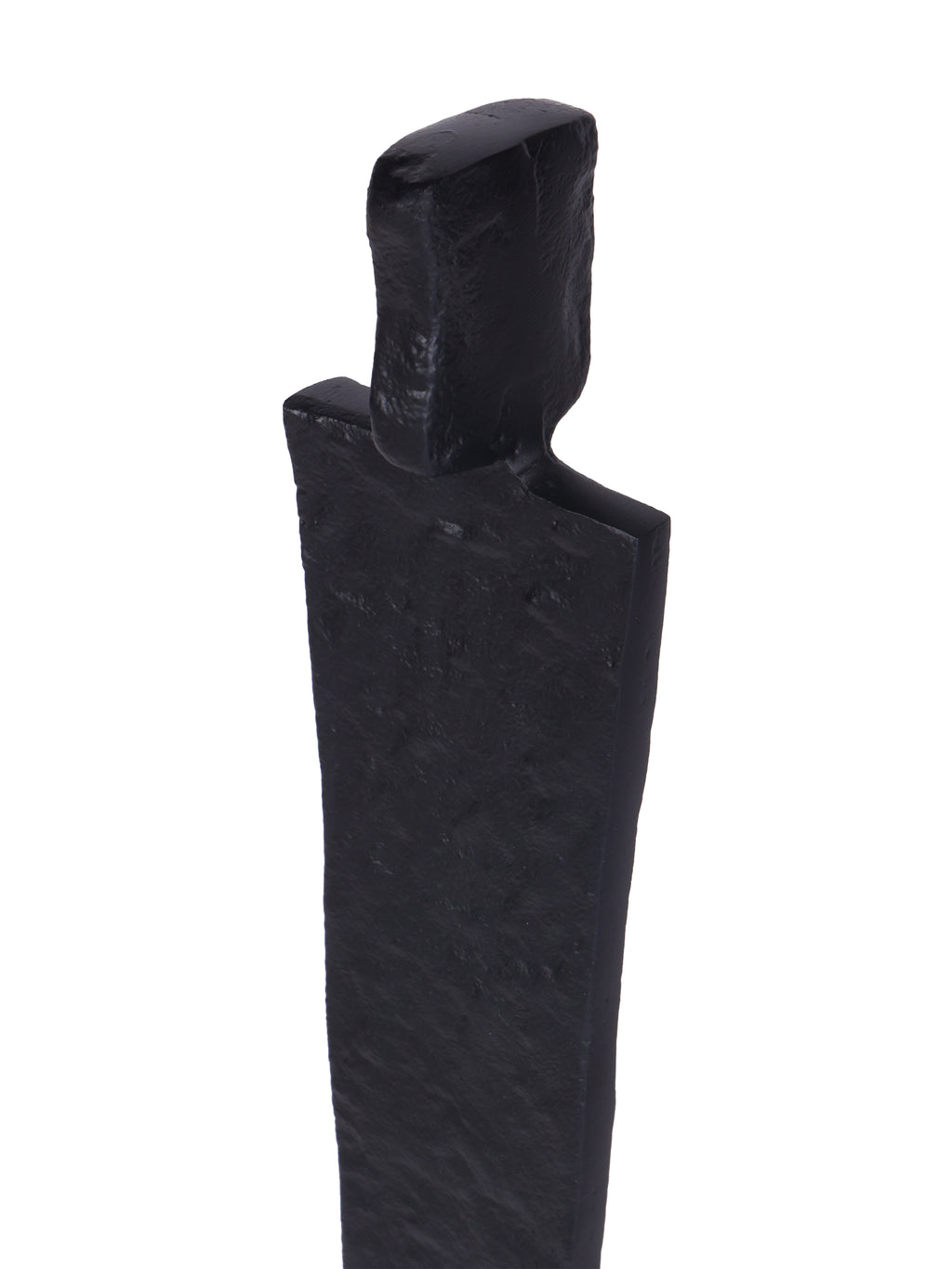 Close-up of the sculpture's rectangular head and broad shoulders, showing the uneven texture of the black finish.