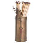 Angled view of the bronze-coloured match holder showing its high sloped rim, loop handle and framed red striking panel, with long matches inside.