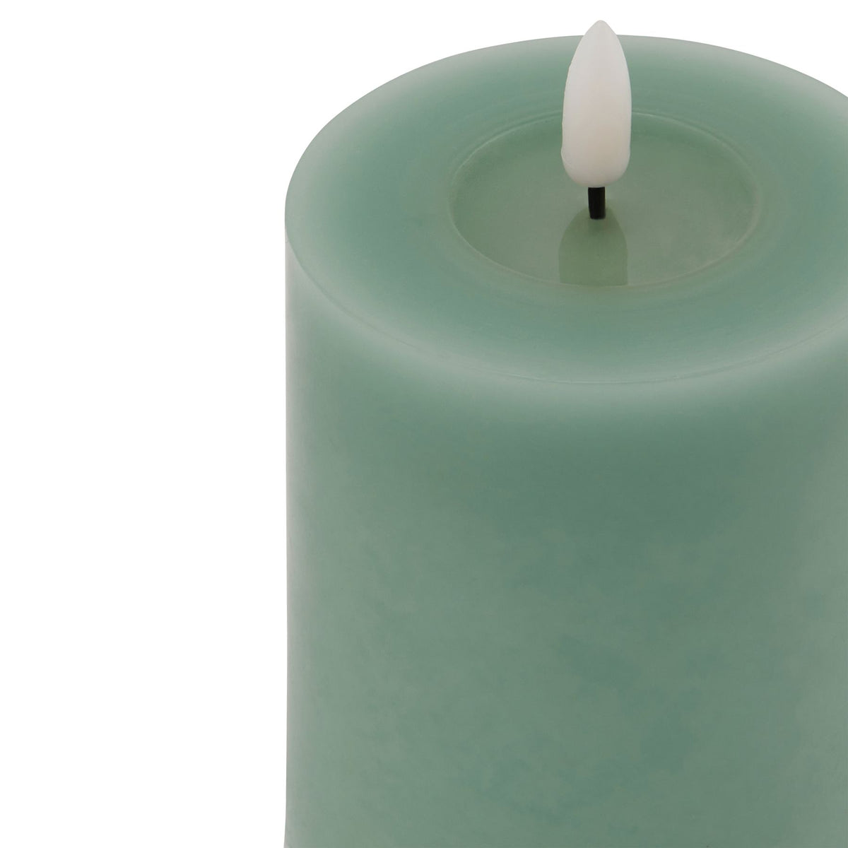 Close-up from above of the green candle's broad circular rim and shallow recess, with a pale flame-shaped insert on a short black stem.