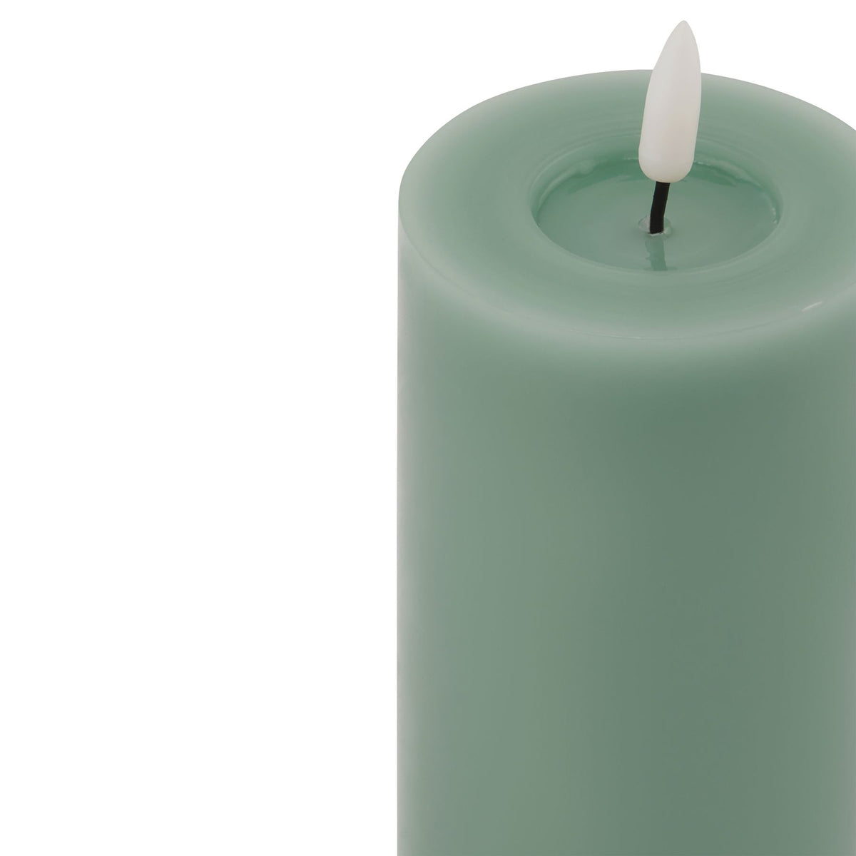 Close-up of the green pillar candle's rounded rim and recessed top, with a pale flame-shaped insert on a dark stem.