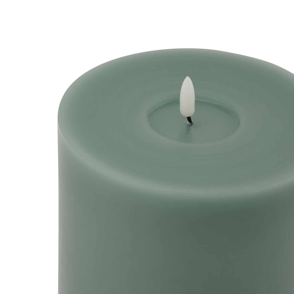 Close-up of the green candle's recessed top, showing subtle circular surface marks and a white flame insert on a short dark stem.