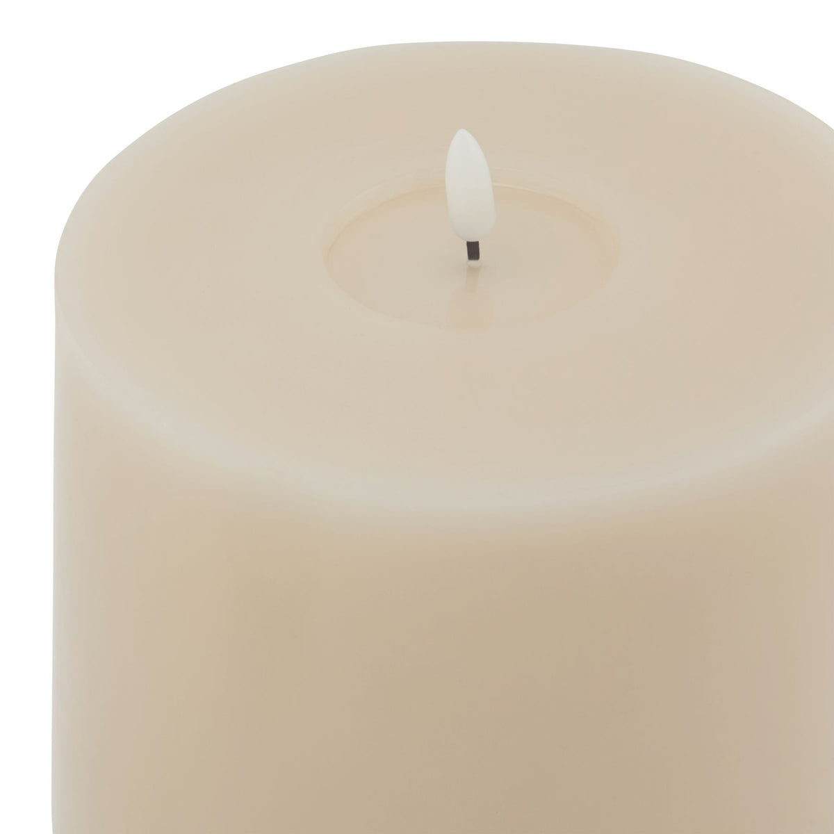 Close view of the candle's wide pale rim and recessed centre surrounding a white flame-shaped insert.