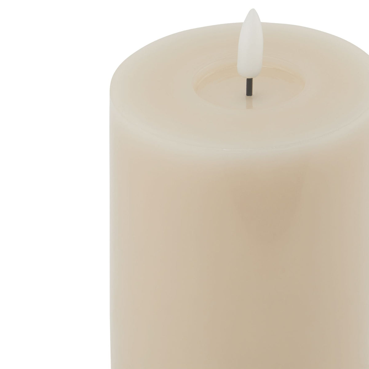 Close-up of the pale candle's circular top recess, with a white flame-shaped insert on a short dark stem.
