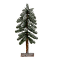 Full view of a narrow decorative pine tree with snowy green branches, an exposed brown trunk and a low rectangular half-log-style base.