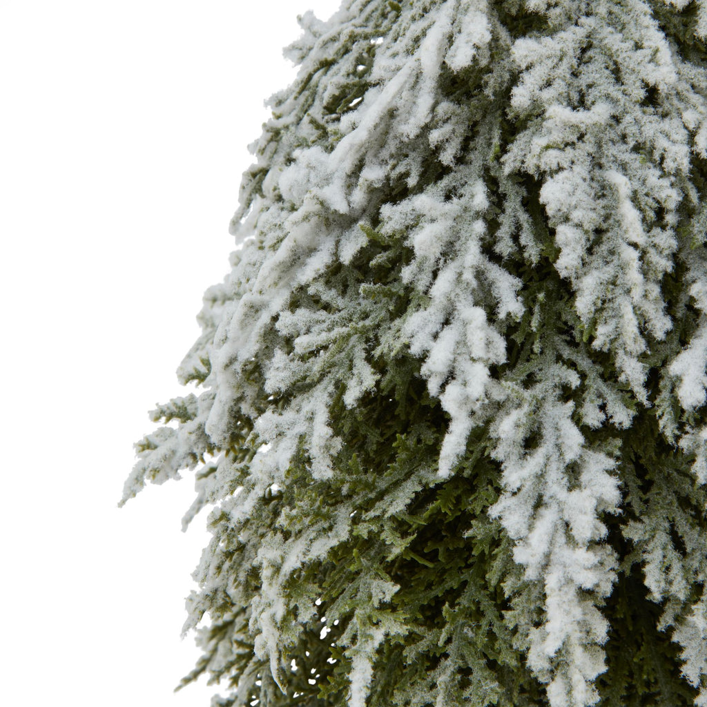 Detail of fine green foliage beneath thick white flocking along the tree's cascading branches.