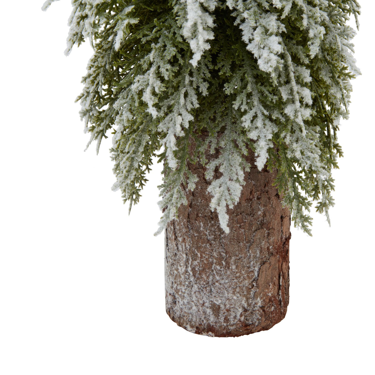 Close-up of the cylindrical bark-textured base beneath drooping green branches dusted with white snow-effect flocking.