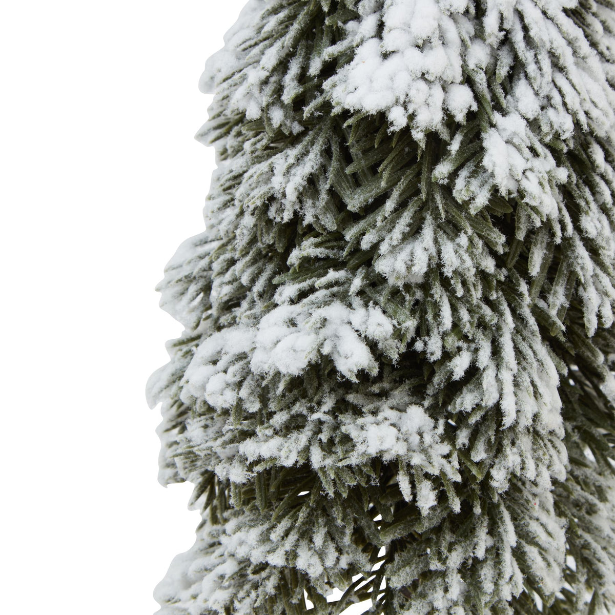 Close-up of layered dark-green tree foliage covered with uneven white snow-like flocking.