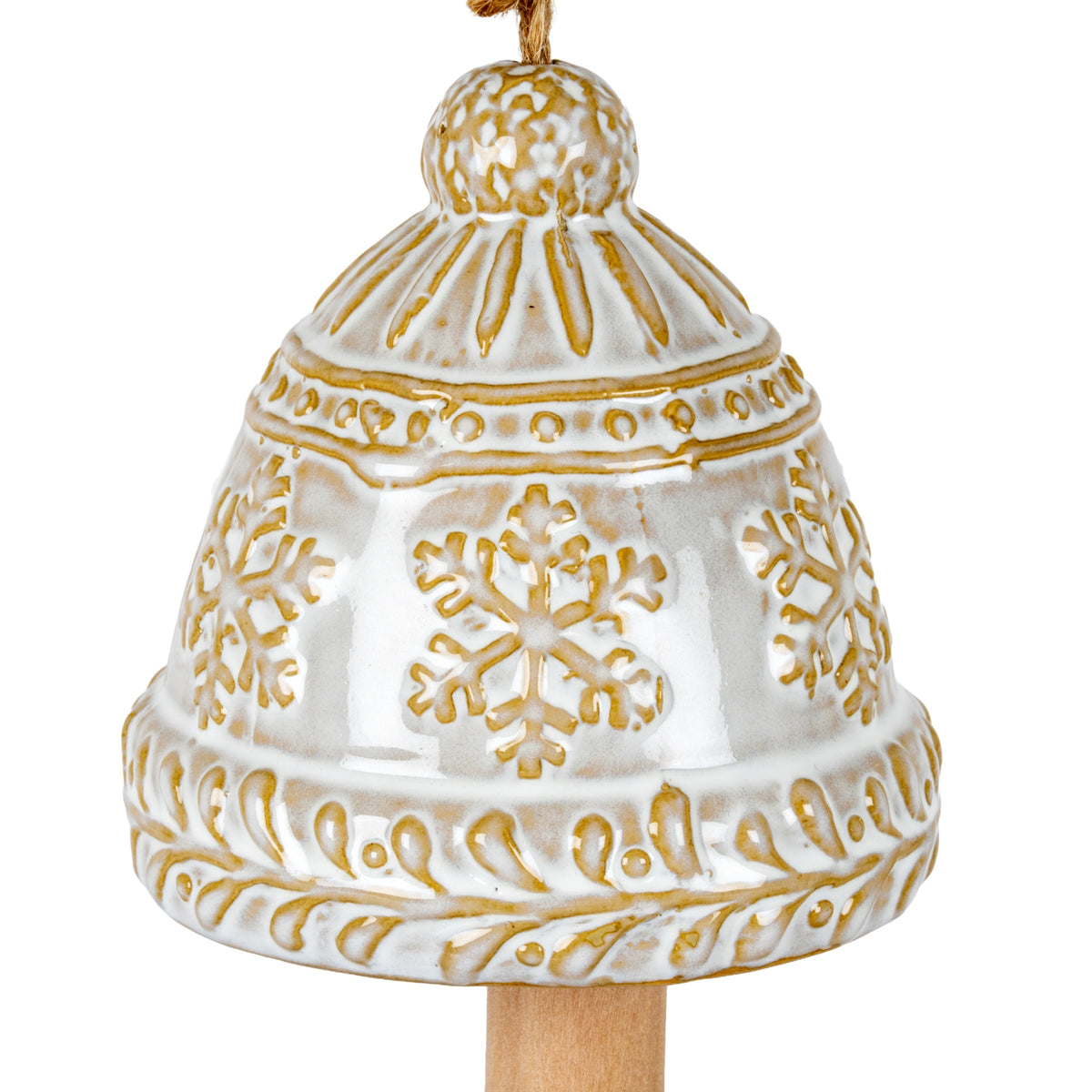 Close-up of the bell's glossy cream finish, ochre-brown snowflakes, dotted upper band and scrolling leaves around the lower edge.