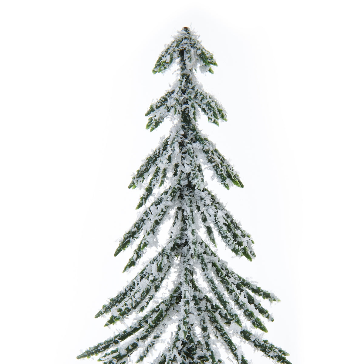 Close-up of the tree's pointed top and fine green branches covered in irregular white snow-like flecks.