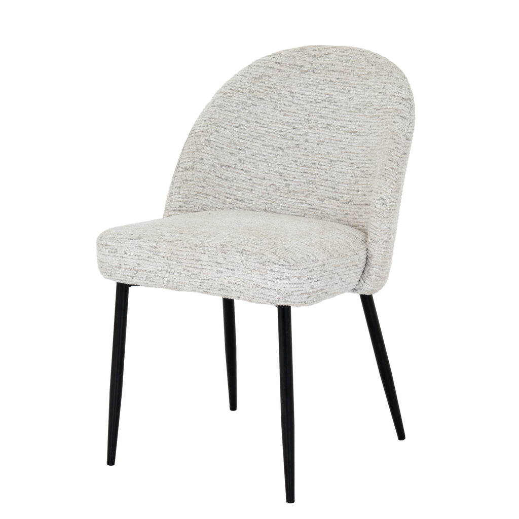 Three-quarter front view of a pale textured armless dining chair with a rounded back, thick seat and four slim black legs.
