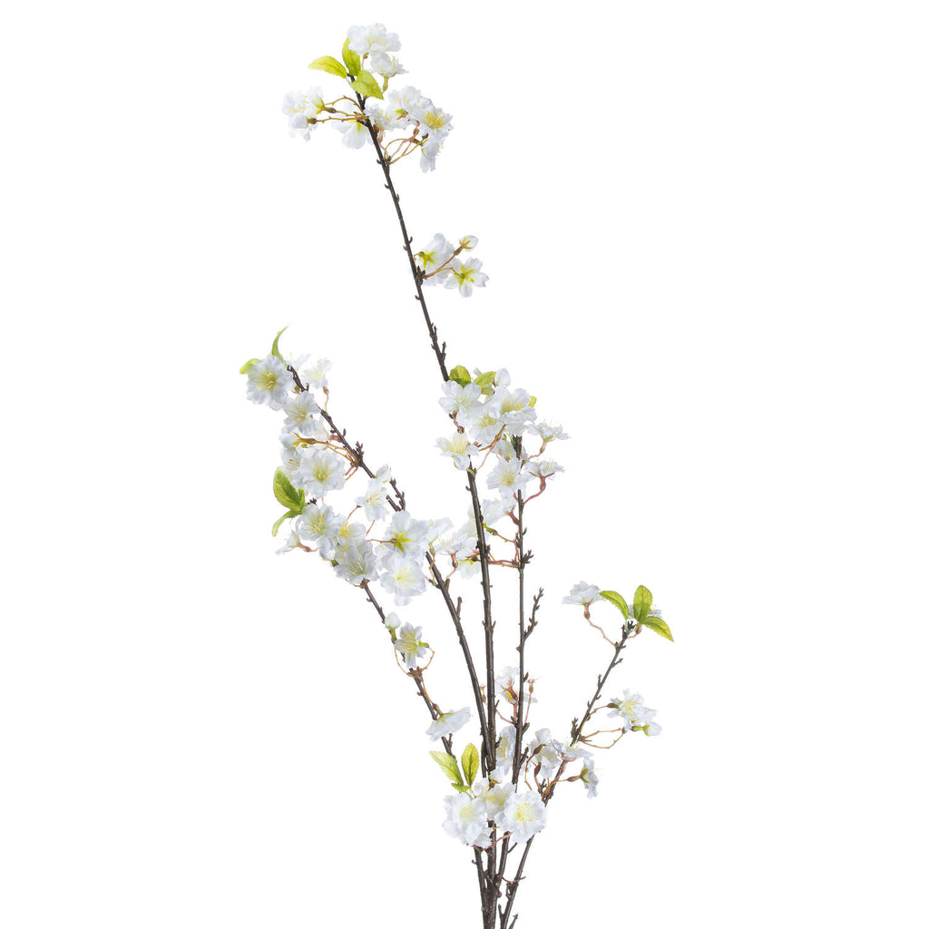 Close view of the artificial spray's upper branches, showing layered white blossoms with pale centres, small buds and pointed green leaves along slender dark-brown stems.