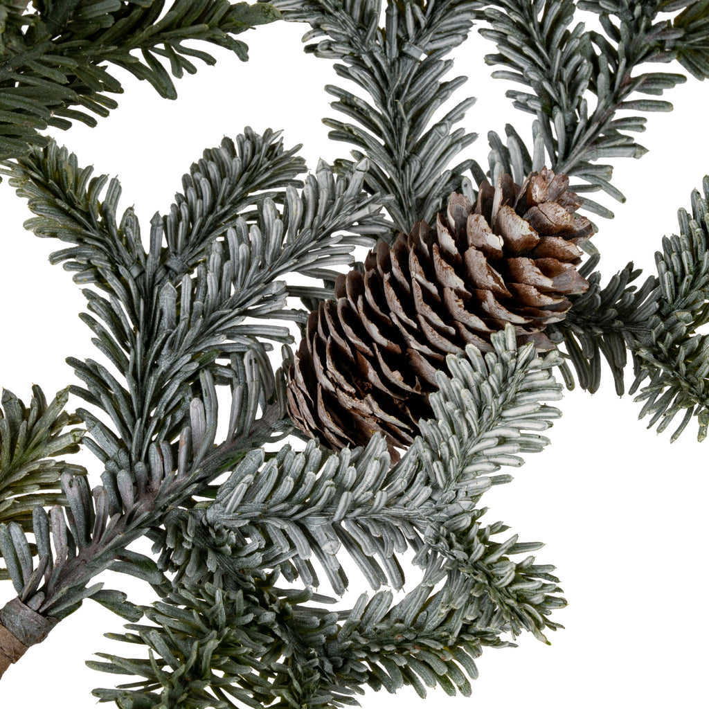 Close-up of a brown pinecone nestled among dark and grey-green needle-like foliage on the artificial spray.