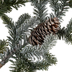 Close-up of a brown pinecone nestled among dark and grey-green needle-like foliage on the artificial spray.