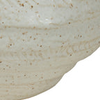 Close-up of the vase body showing shallow textured markings, irregular horizontal bands and brown speckles in the ivory glaze.