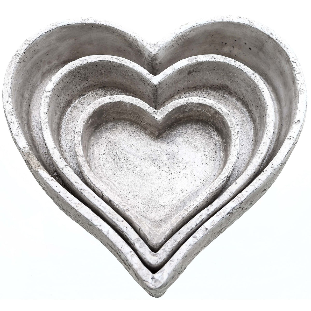 Three graduated pale grey heart-shaped dishes nested together on a white background, showing rough edges and speckled open interiors.
