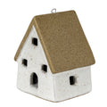 Three-quarter view of a cottage decoration with a steep speckled tan roof, off-white walls, square window openings and an arched doorway.