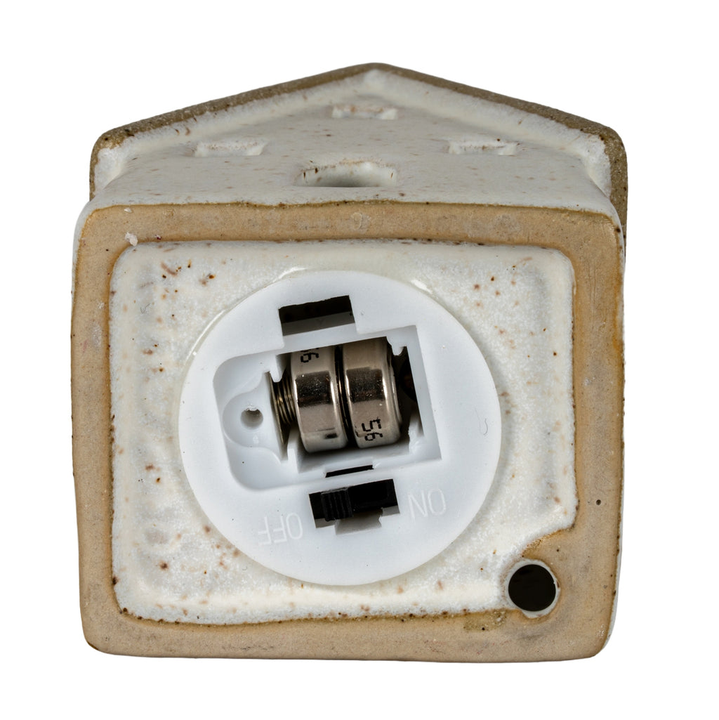 Underside of the cottage sample showing a round white battery module with two fitted button cells and a black switch beside ON and OFF markings.