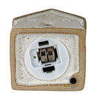 Underside of the cottage sample showing a round white battery module with two fitted button cells and a black switch beside ON and OFF markings.