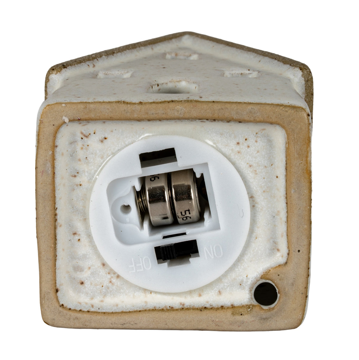 Underside of the cottage sample showing a round white battery module with two fitted button cells and a black switch beside ON and OFF markings.