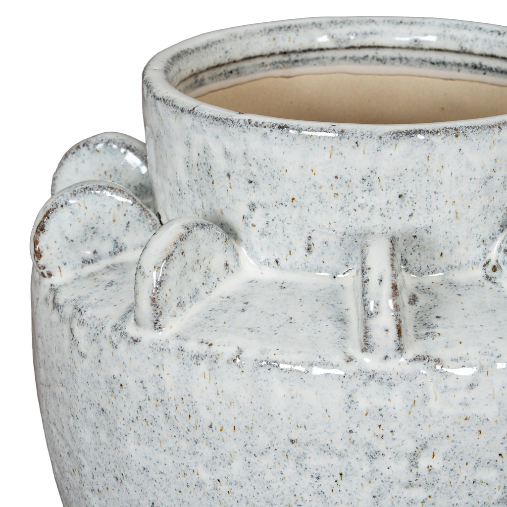 Close detail of the vase neck and rounded shoulder fins, with dark speckles and brown accents along their curved edges.