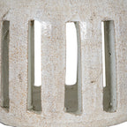 Close-up of the candle holder's tall rectangular openings and rounded lower edge, with brown flecks and fine irregular lines across the white surface.