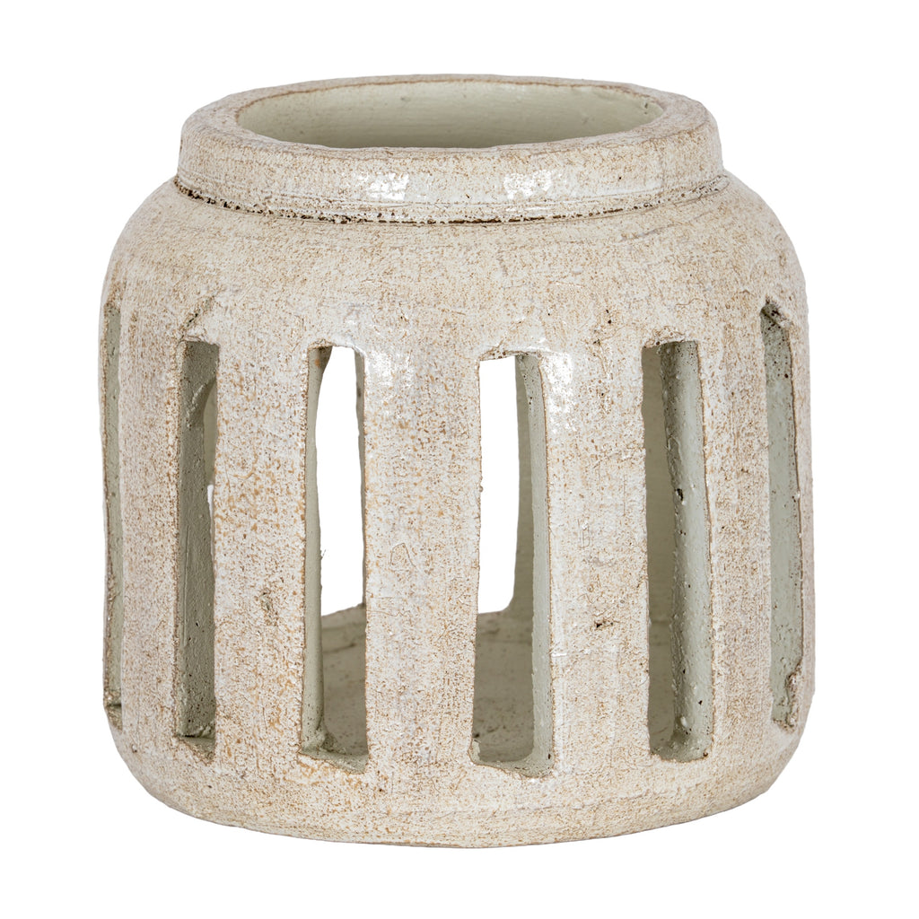 Rounded cream candle holder with brown speckles, a broad raised rim and tall rectangular openings around the body.