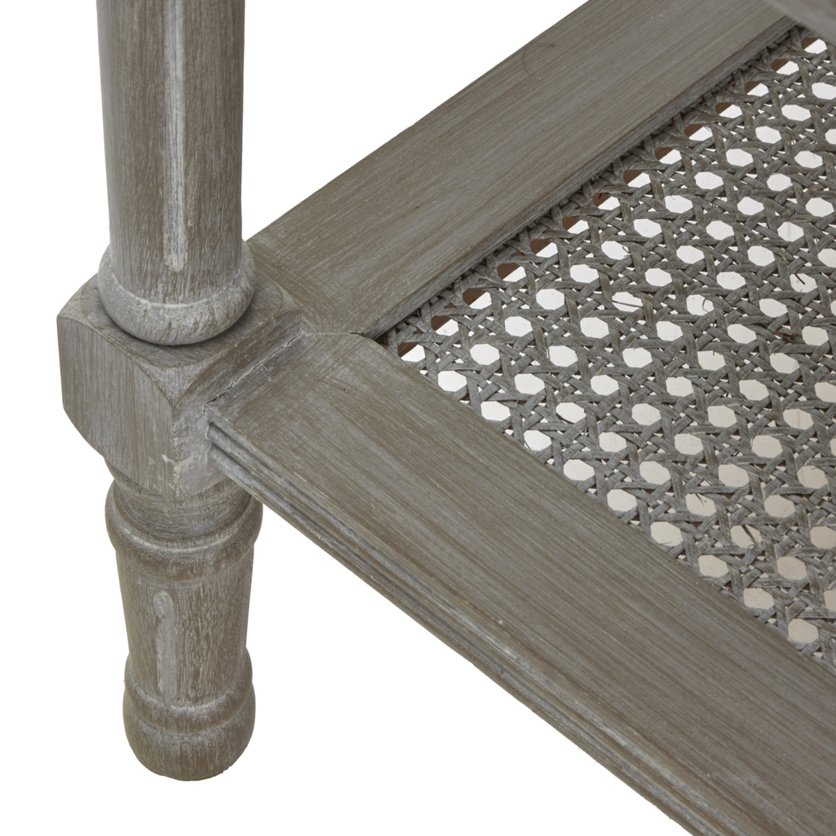 Detail of a turned-profile lower leg beside the shelf frame and its open weave with repeating small openings.