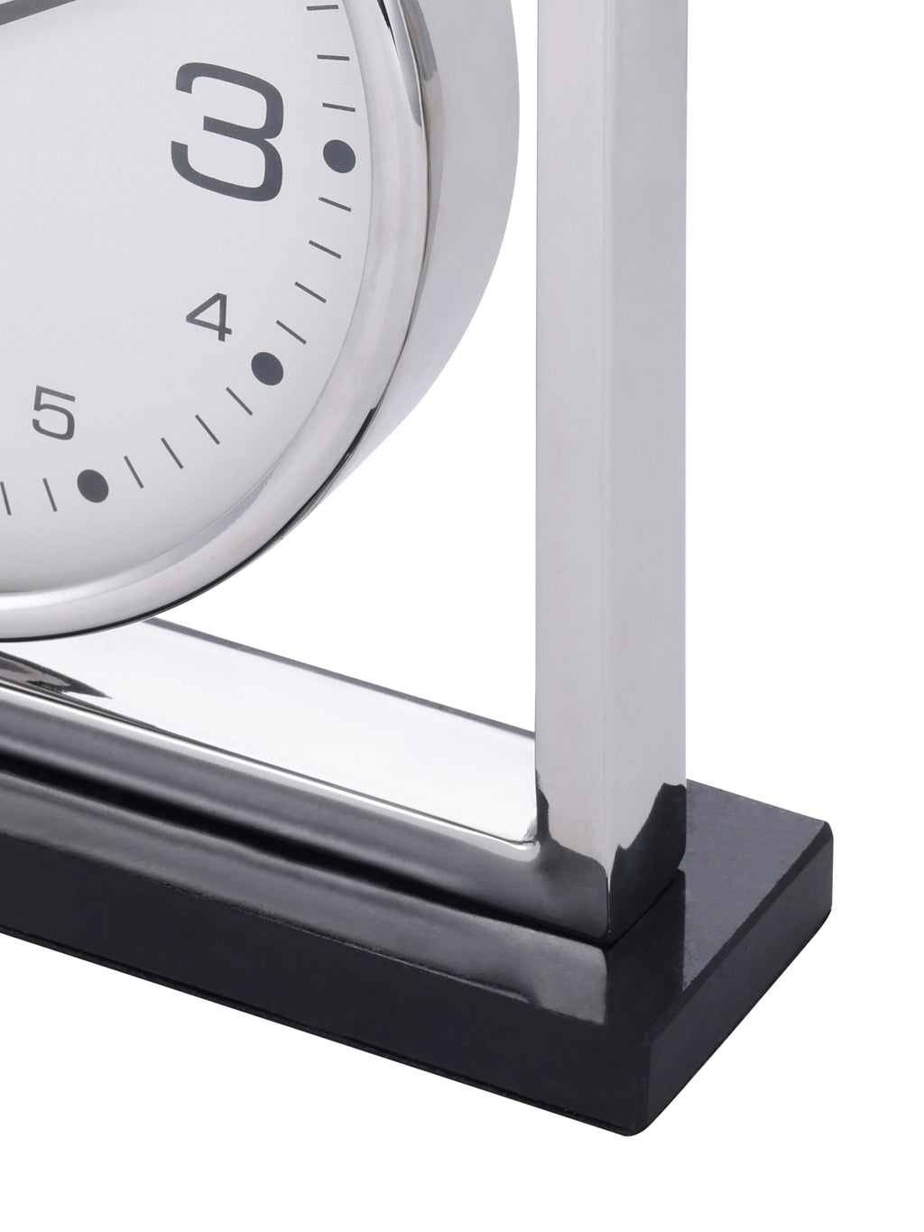 Detail of the clock's lower frame corner and polished black granite base beneath the white dial.