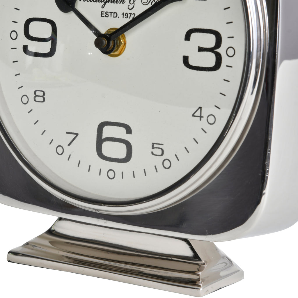 Close-up of the lower clock face and pedestal, showing the large six and the reflective stepped silver base.