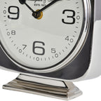 Close-up of the lower clock face and pedestal, showing the large six and the reflective stepped silver base.