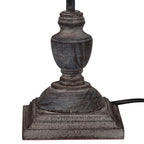 Close view of the lamp's curved grey-washed base and stepped square plinth, with a black cord extending to the right.