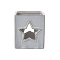 Front view of the off-white square candle holder with a tan-edged star opening and fine speckles.
