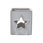 Front view of the off-white square candle holder with a tan-edged star opening and fine speckles.
