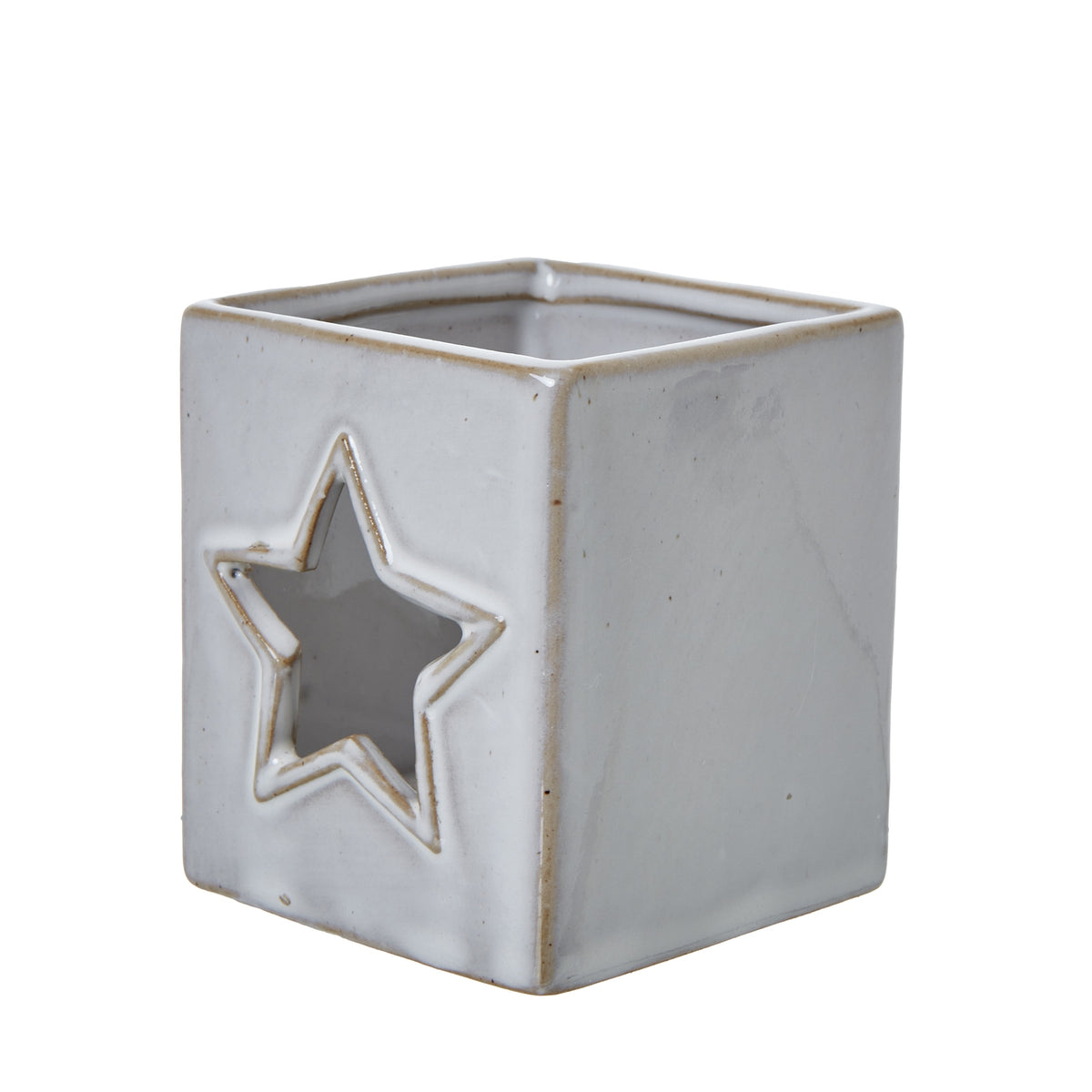 Angled view of the ceramic candle holder showing a star cut-out on one face, a plain side and the open square top.