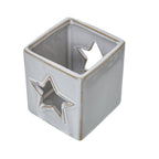 View from above into the square candle holder, showing its speckled interior, tan-edged rim and opposing star openings.