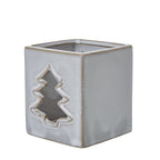 Angled view of the ceramic candle holder showing the tree aperture beside a plain side and lightly speckled glossy finish.