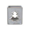 Front view of the off-white square candle holder with a tan-edged tree cut-out and open top.