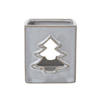 Front view of the off-white square candle holder with a tan-edged tree cut-out and open top.
