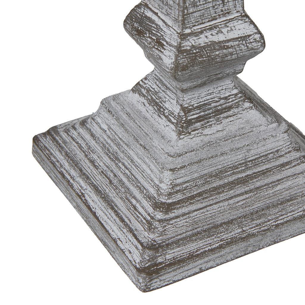 Angled detail of the stepped square lamp foot, with rubbed white highlights outlining its layers.