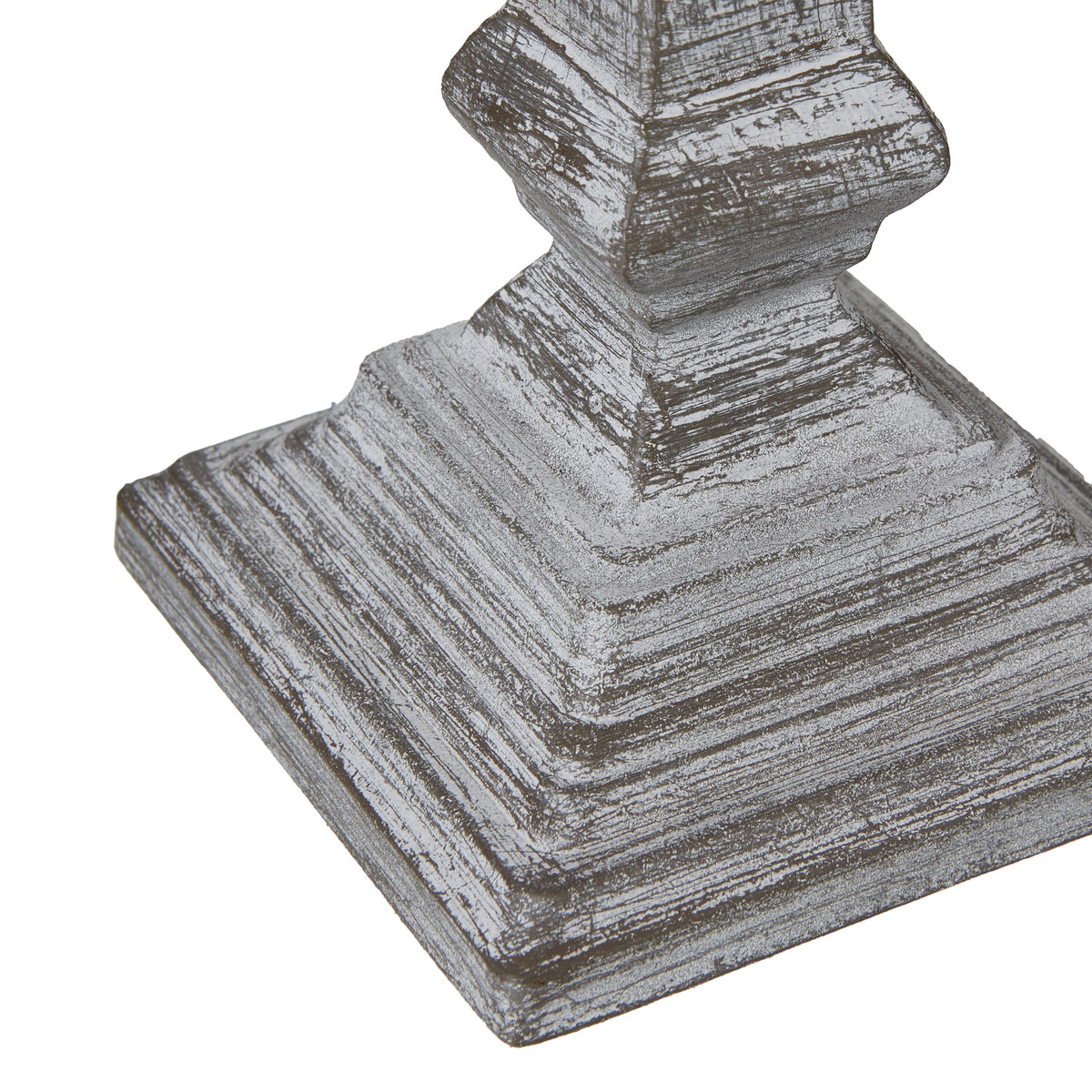 Angled detail of the stepped square lamp foot, with rubbed white highlights outlining its layers.