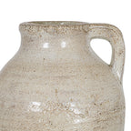Close-up of the cream jug's shoulder and squared loop handle, showing brown speckles, surface texture and highlights across the finish.