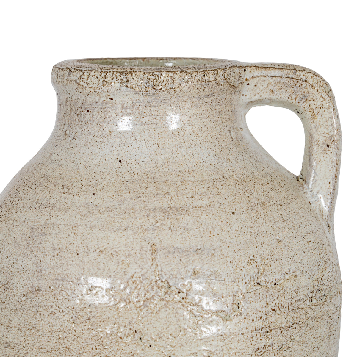 Close-up of the cream jug's shoulder and squared loop handle, showing brown speckles, surface texture and highlights across the finish.