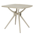 Three-quarter view of the putty-toned square dining table, showing the rounded tabletop corners and branching base with splayed legs.