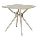 Three-quarter view of the putty-toned square dining table, showing the rounded tabletop corners and branching base with splayed legs.
