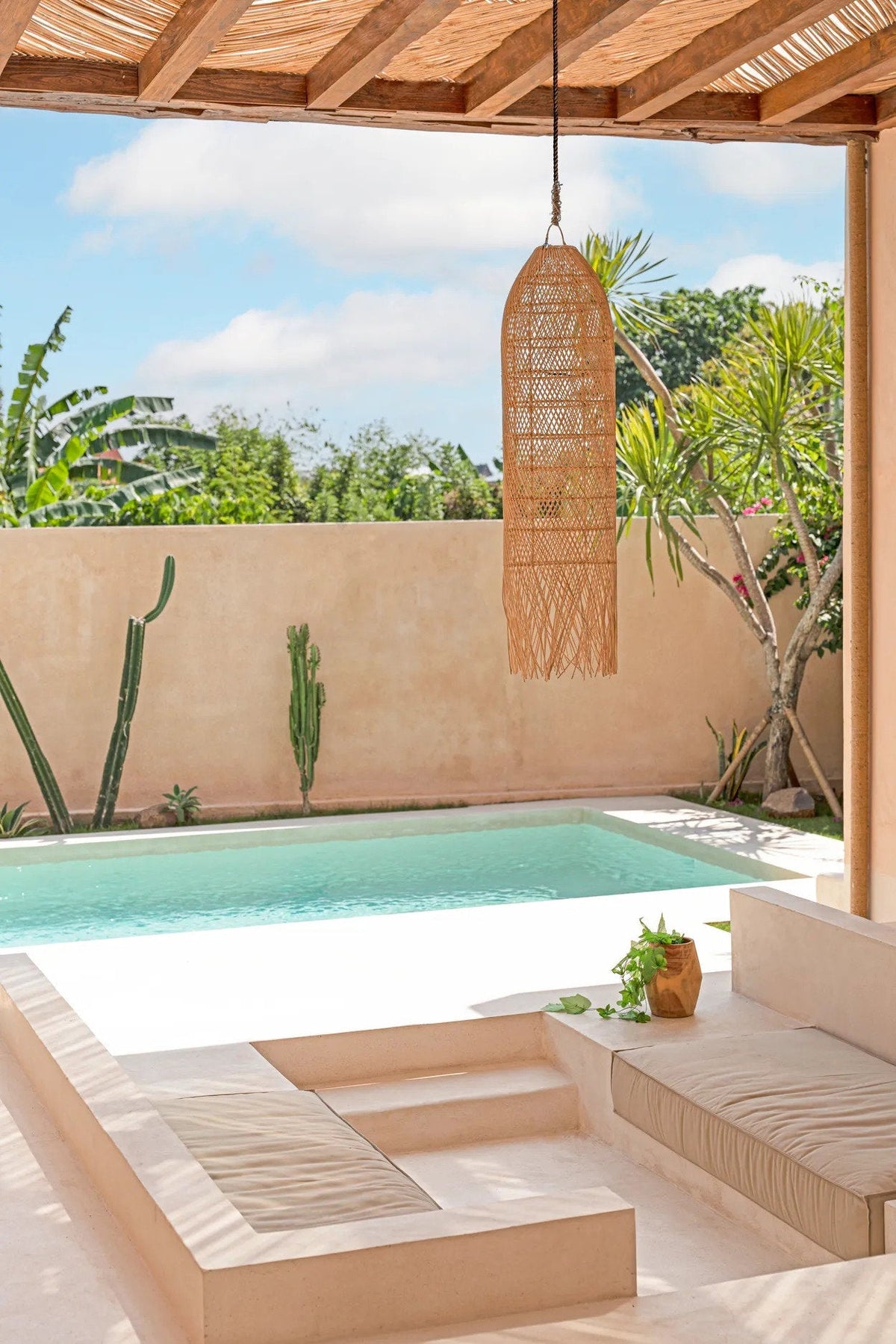 Squid Rattan Pendant Light – Natural, Large – suspended beside a pool beneath a timber roof