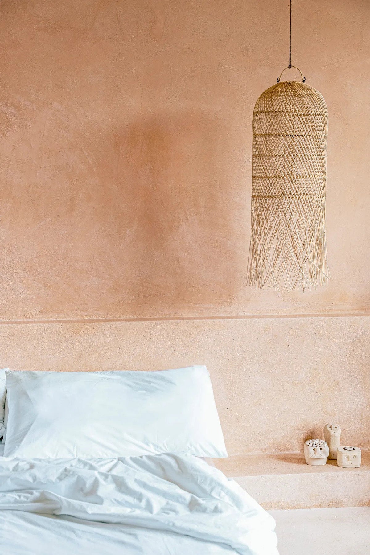 Squid Rattan Pendant Light – Natural, Medium — styled above a bed