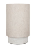 Unlit table lamp with a tall cream linen drum shade above a low cylindrical white marble base.