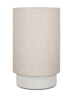 Unlit table lamp with a tall cream linen drum shade above a low cylindrical white marble base.